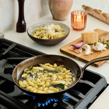 Carbon steel little farmhouse skillet by Smithey - on stove.