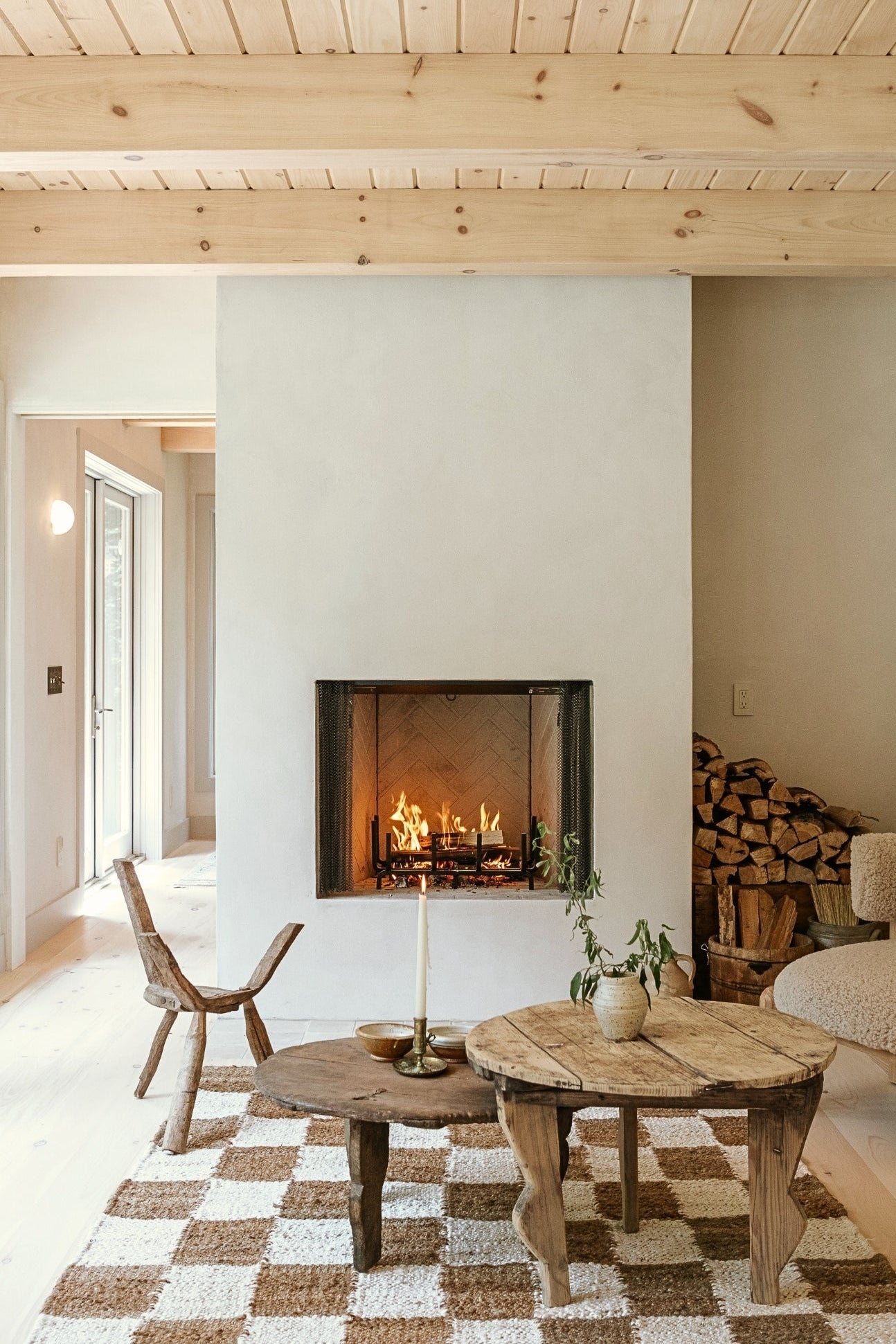 Cozy living room with a fireplace, wooden coffee table, and checkered rug.