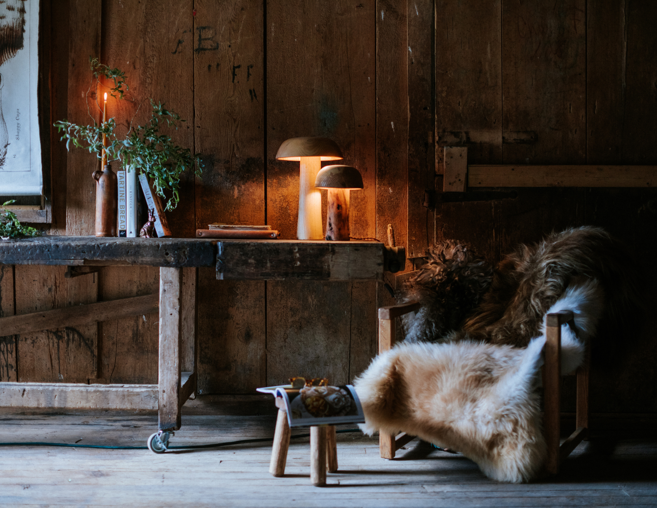 Sheepskins in cozy livingroom setting, wooden muchroom lights and vintage furniture