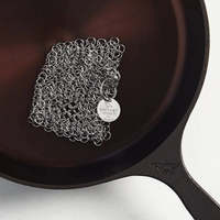 Cast iron skillet with chainmail scrubber on a white background